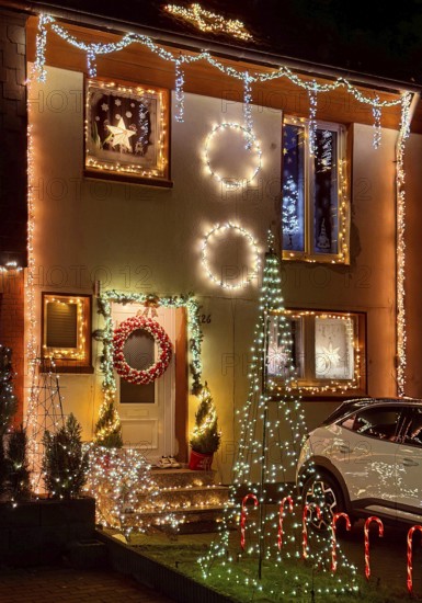 Christmassy kitschy illuminated façade of a row house in Gelsenkirchen-Ückendorf in the evening, Ruhr area, North Rhine-Westphalia, Germany