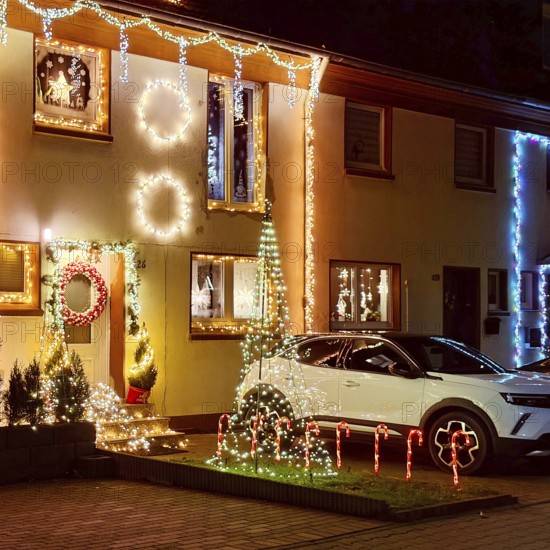 Christmassy kitschy illuminated façade of a row house in Gelsenkirchen-Ückendorf in the evening, Ruhr area, North Rhine-Westphalia, Germany