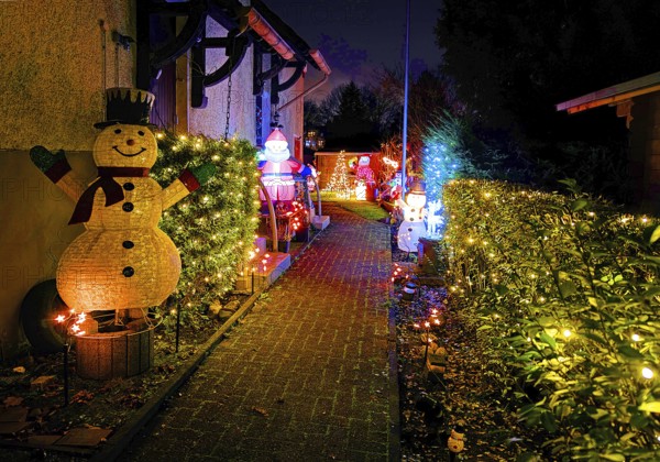 Christmassy kitschy illuminated entrance of a terraced house in Gelsenkirchen-Ückendorf in the evening, Ruhr area, North Rhine-Westphalia, Germany