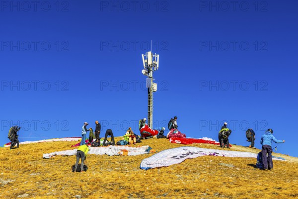 Paragliders prepare for takeoff below the transmitter and cell phone tower, summit of the Corne de Sorebois, Val d'Anniviers, Valais Alps, Canton of Valais, Switzerland