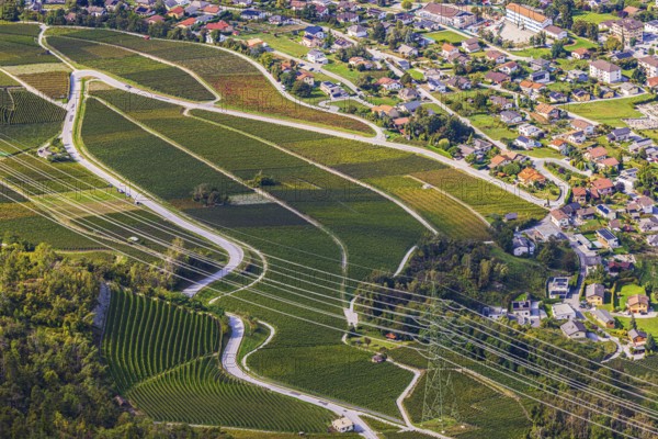 Power lines across vineyards and fields, in the back the village of Chalais, view of Vercorin, Val d'Anniviers, Valais Alps, Canton of Valais, Switzerland