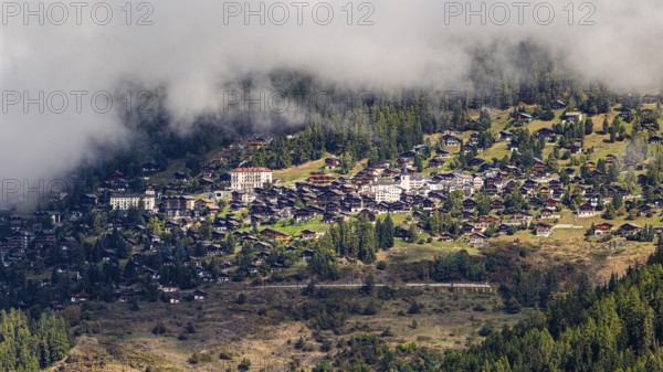 Fog is gathering over the mountain village of Saint-Luc, Val d'Anniviers, Valais Alps, Canton of Valais, Switzerland