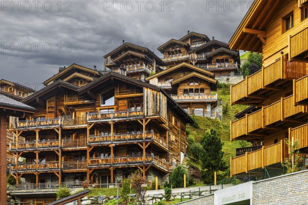 Dark clouds over wooden holiday homes, Grimentz, Val d'Anniviers, Valais Alps, Canton of Valais, Switzerland