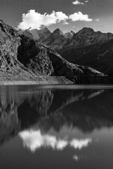 The Lac de Moiry reservoir, in the background the peaks of the Grand Cornier, Tete Blanche and Pointe Moiry mountains, black and white photo, Val d'Anniviers, Valais Alps, Canton of Valais, Switzerland