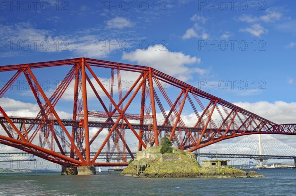 A large, red bridge stretches over water, on which a small island lies, fortification from the First World War, railway bridge, Firth of Forth, Edinburgh, Scotland, Great Britain