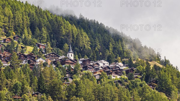 Rising fog over the mountain village of Saint-Luc, Val d'Anniviers, Valais Alps, Canton of Valais, Switzerland