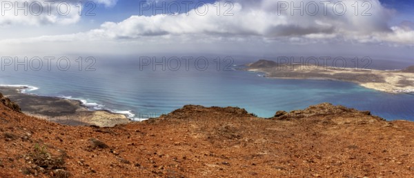 Wide coastline with blue ocean and sky, dotted with clouds overlooking La Graciosa, Haria Lanzarote, Canary Island