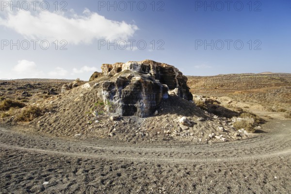 An abandoned quarry with rock formations under a sky with scattered clouds, Los Roferos (Stratified City or Antigua Rofera) Lanzarote
