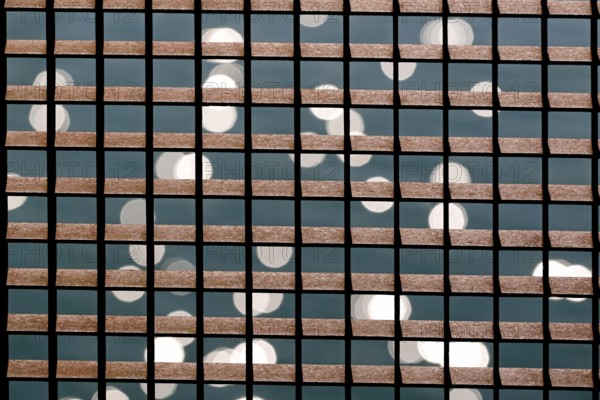 Rusty grid in front of a reflecting water surface, North Rhine-Westphalia, Germany