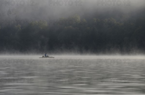 Hennesee, fog, rising clouds of fog, anglers in the boat, Hennetalsperre, Sauerland-Rothaargebirge nature park Park, North Rhine-Westphalia, Germany