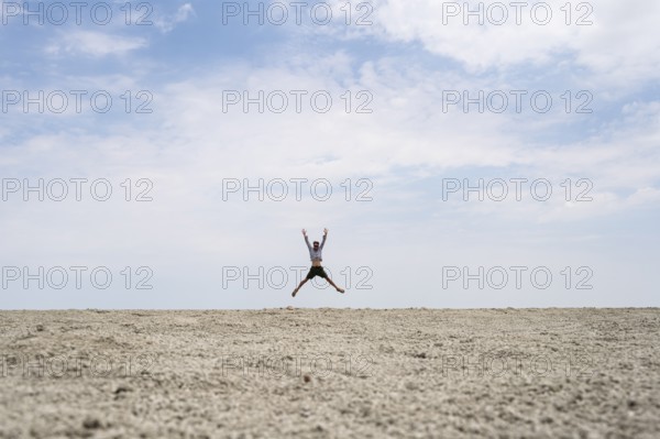 Abstract, man jumping on the Etosha pan, salt pan, Etosha National Park, Namibia