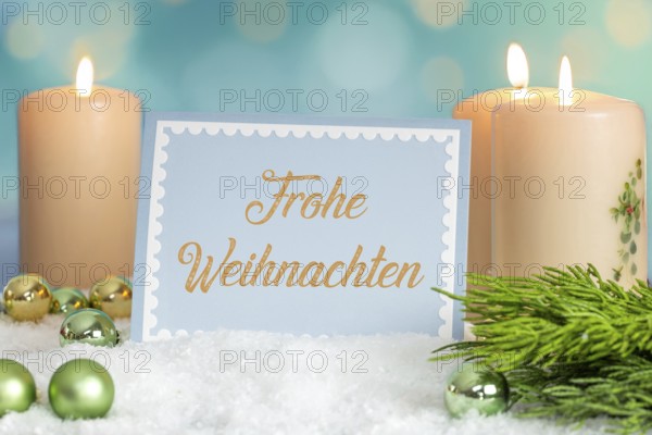 Greeting card with the inscription FROHE WEIHNAHCHTEN between Christmas accessories with bokeh in the background (digitally reworked)
