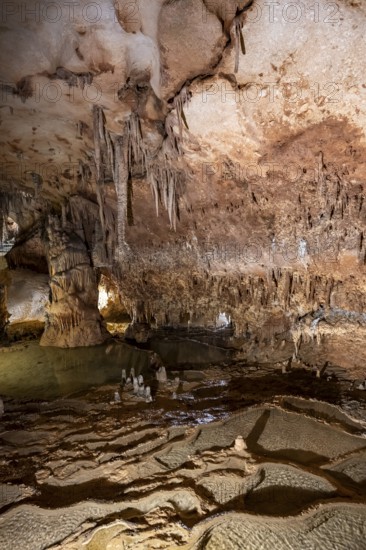 Stalactites and stalagmites, rock formations in a stalactite cave with water basin, Grotta del Fico, Gulf of Orosei, Baunei, Sardinia, Italy
