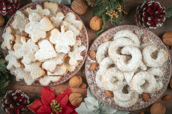 Vanilla croissants and Christmas cookies on two plates with festive decoration