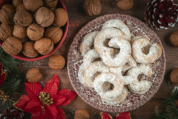 Vanilla croissants on a plate next to walnuts and Christmas decoration