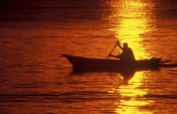 Silhouette of a fisherman in his boat at sunrise near Mikadi Beach, Dar es-Salaam, Tanzania, Africa, June 2000, vintage, retro, old, historic