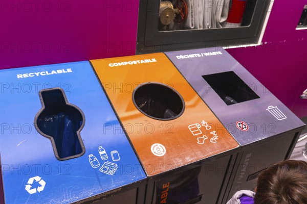 Colorful recycling bins at an airport promoting waste separation into recyclable, compostable, and general waste, enhancing responsible disposal and environmental sustainability