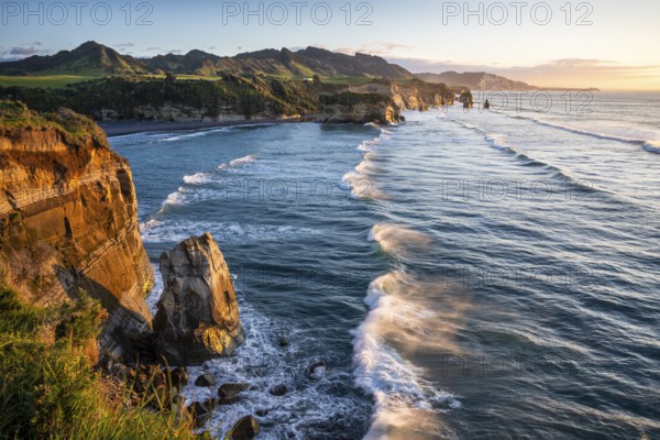 The Three Sisters and Elephant Rock formations, sea, evening, golden hour, sunset. Taranaki Region, North Island, New Zealand