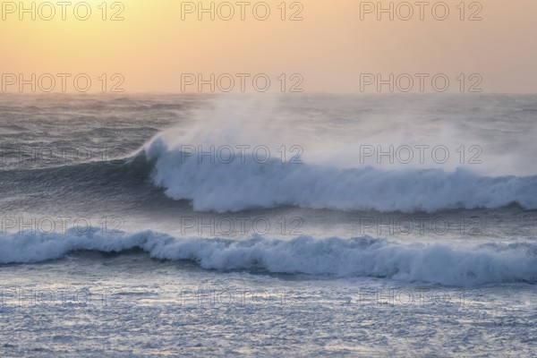 Ocean waves, strong surf, sunset, west coast of the Taranaki region, North Island, New Zealand