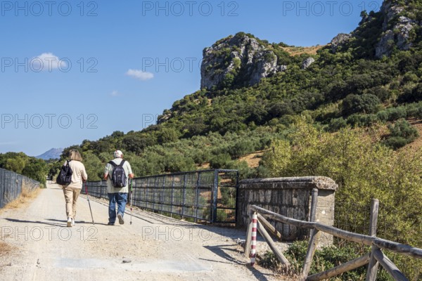 Hiking older couple, bridge Viaducto de Zaframagón, cycle path Via Verde de la Sierra, Puerto Serrano to Olvera, old railroad track, near village Coripe, Andalusia, Spain