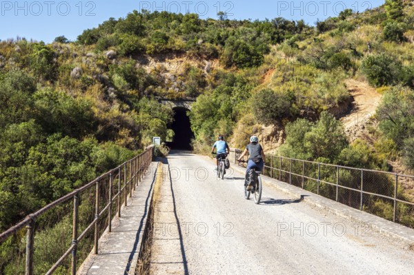 Couple riding bicycle, bridge Viaducto de Gillete, cycle path Via Verde de la Sierra, Puerto Serrano to Olvera, old railroad track, cycle path on bridge, near village Coripe, Andalusia, Spain