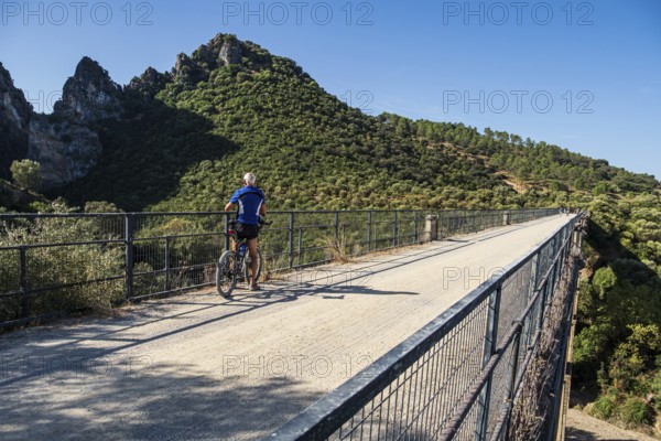 Cyclist takes a break, Viaducto de Zaframagón, cycle path Via Verde de la Sierra, Puerto Serrano to Olvera, old railroad track, cycle path on bridge, near village Coripe, Andalusia, Spain