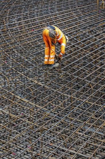 Assembly of reinforcing steel for the reinforced concrete foundation of a wind turbine, a mesh of rebar and reinforcing steel mesh, connecting the steel elements with binding wire, twisting with tongs, over 100 tons of reinforcing steel were used, the wind turbine will have a hub height of 160 meters, part of a new wind farm in Sauerland, near Balve, North Rhine-Westphalia, Germany