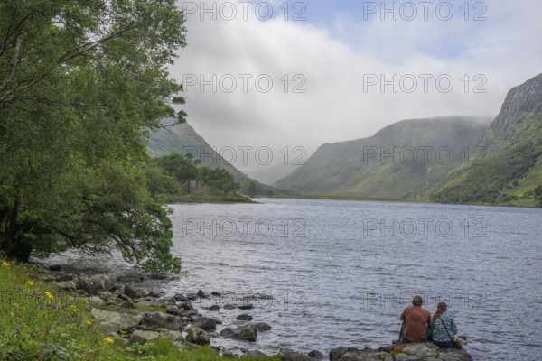 Couple sitting at Loch Beagh, Glenveagh National Park, Cross Roads, County Donegal, Ireland
