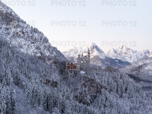Magnificent Neuschwanstein Castle in the midst of a snowy mountain landscape with majestic peaks, Schwangau near Füssen, Ostallgäu, Allgäu, Bavaria, Germany