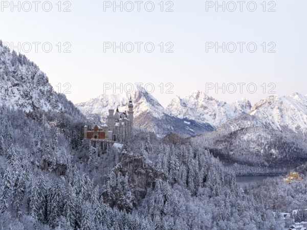 Romantic Neuschwanstein Castle nestled in winter mountain scenery and snow-covered forests, Schwangau near Füssen, Ostallgäu, Allgäu, Bavaria, Germany