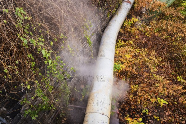 District heating pipeline in front of old industrial buildings on the banks of the Wupper, Wuppertal, Germany