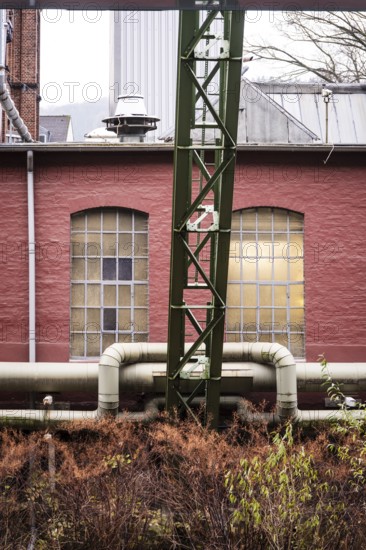 District heating pipeline in front of old industrial buildings on the banks of the Wupper, Wuppertal, Germany