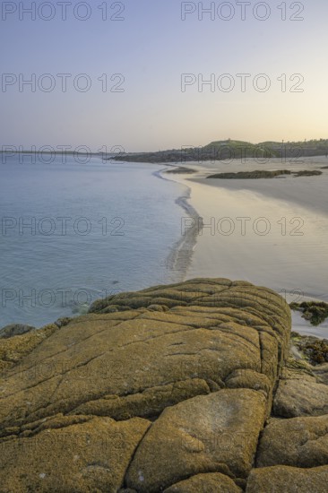 Granite rocks in the evening light and turquoise blue sea at Gurteen Beach, Roundstone, County Galway, Ireland