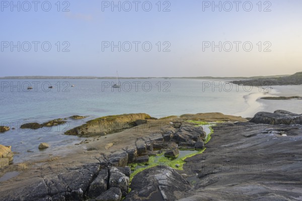 Granite rocks in the evening light and turquoise blue sea at Gurteen Beach, Roundstone, County Galway, Ireland