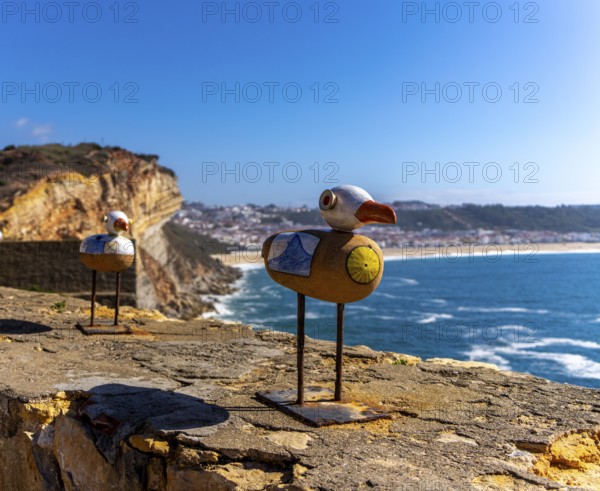 Wooden seagulls, art on the fortress at Farol de Nazare lighthouse, an annual meeting place in autumn to watch the big waves on the North Beach, Nazaré, Portugal