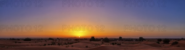A calming sunrise over the desert that makes the sky shine in vivid colors, Sahara in Morocco