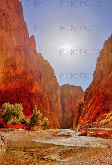 Bright orange rocks under bright sun in an impressive gorge, Todra Gorge in Morocco