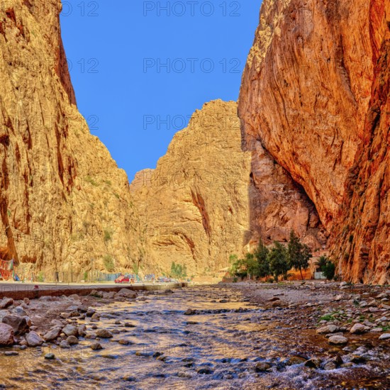 Dramatic gorge with river lined with towering red rocks, Todra Gorge in Morocco