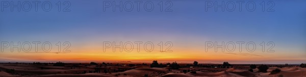 A wide panorama of the desert at sunrise with a calm, colorful sky, Sahara in Morocco