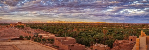 Dramatic desert panorama with oasis and mountains in the background at sunset, Skoura in Morocco