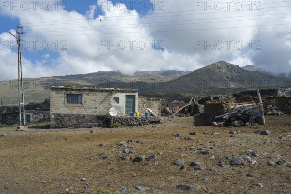 A simple stone house with power lines in a mountainous landscape, village at the foot of Great Ararat, Büyük Agri Dagi, Cevirme, Çevirme, Dogubayazit, Dogubayazit, Dogubeyazit, Agri Province, Eastern Anatolia, Anatolia, Turkey