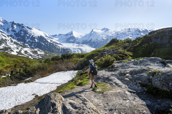 Hikers on the Portage Pass Trail, snow-covered mountains and Portage Glacier glaciers, near Whittier, Alaska, USA