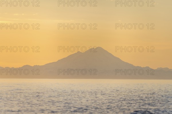 View of Cook Inlet on white mountain peaks of Mount Redoubt at sunset, midnight sun, Aleutian mountains, Anchor Point, Anchor River State Recreation Area, Alaska, USA