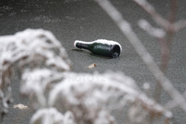 Symbolic picture of garbage in nature, bottle on frozen lake, winter, Germany