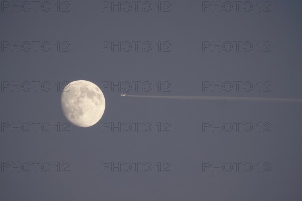Airplane and moon, winter evening, Germany