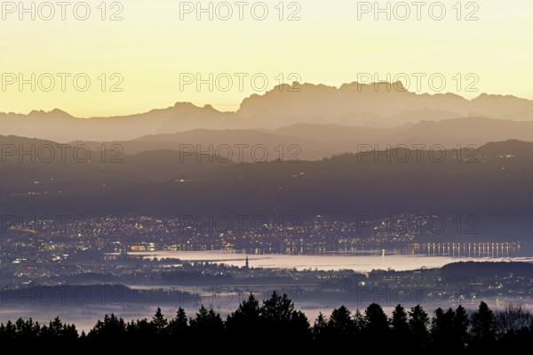 View from Horben of Lake Zug with the town of Cham and Zug, behind it the snow-capped mountains Flübrig and Vrenelisgärtli in the light of dawn, Beinwil-Freiamt, Canton, Aargau, Switzerland