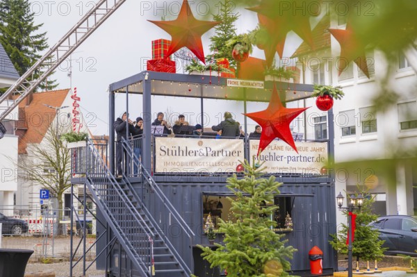 An elevated stage with musicians surrounded by Christmas decorations and spectators, Sindelfingen, Böblingen district, Germany