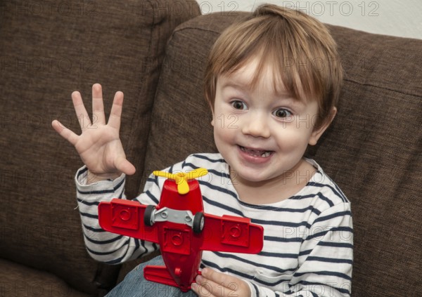 Little boy with gestures, 3 years old, playing with airplane indoors in Ystad, Skåne County, Sweden, Scandinavia