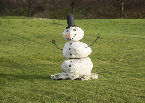 Snowman on green lawn at green winter in Ystad, Skåne County, Sweden, Scandinavia