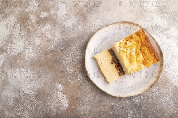 ?ottage cheese ?asserole, Curd cake, with dried apricots and raisins on brown concrete background, top view, flat lay, copy space, minimalism
